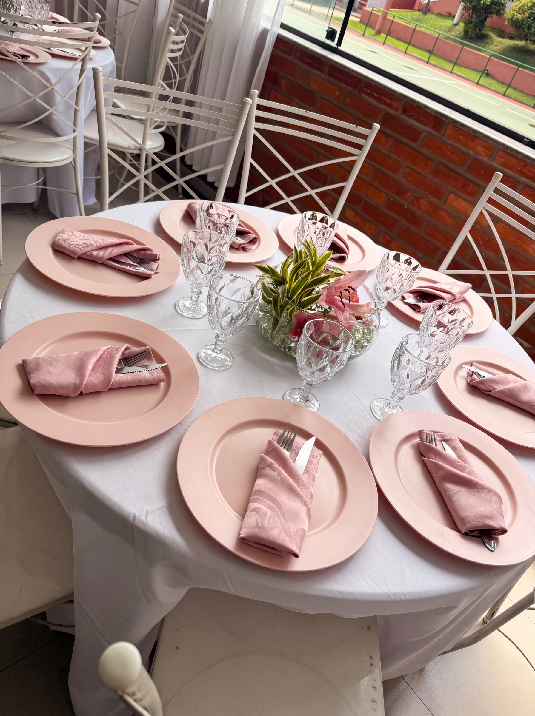 Mesa posta com pratos rosas e taças